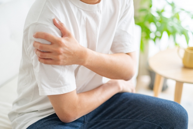 肩を抑えて痛がる男性